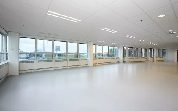 Lichte, lege kantoorruimte met grote ramen in het Rivium Quadrant.